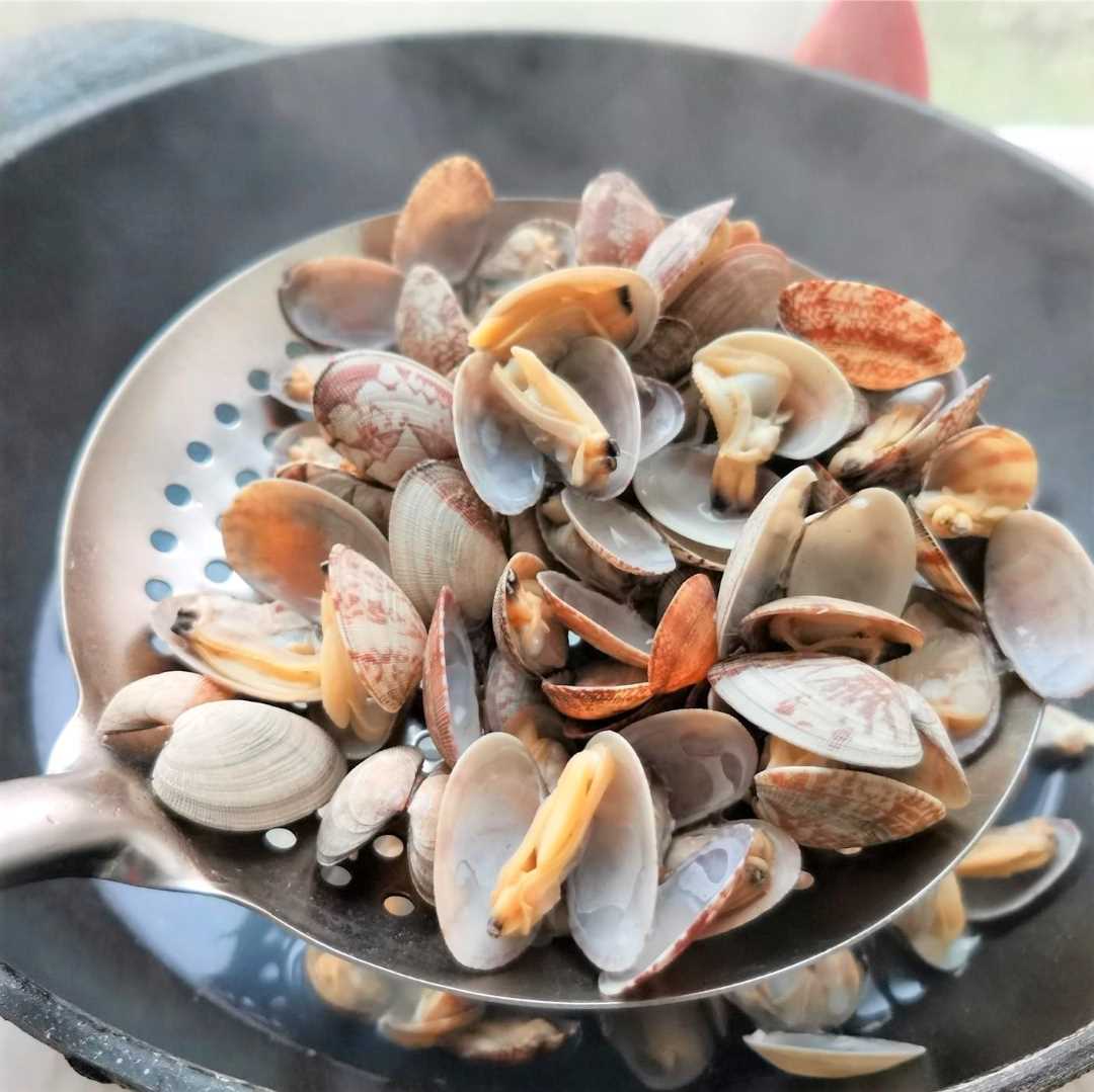 pour the clams and cook until the shell is opened