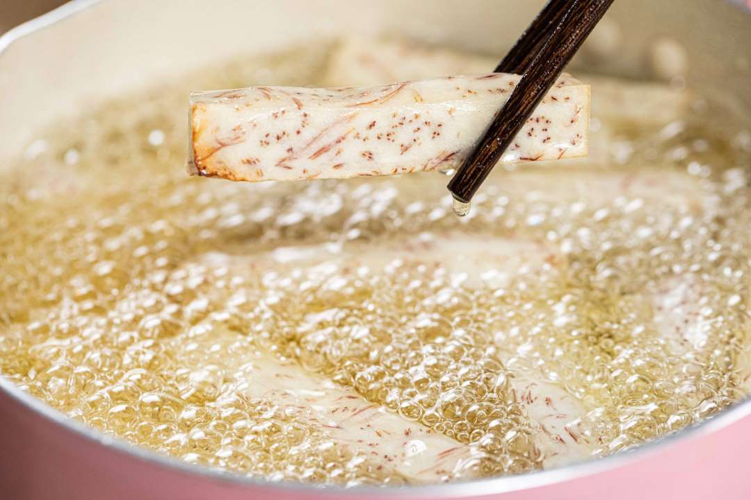 Pour the taro sticks into the oil pan and deep fry over low heat for about 8 minutes.