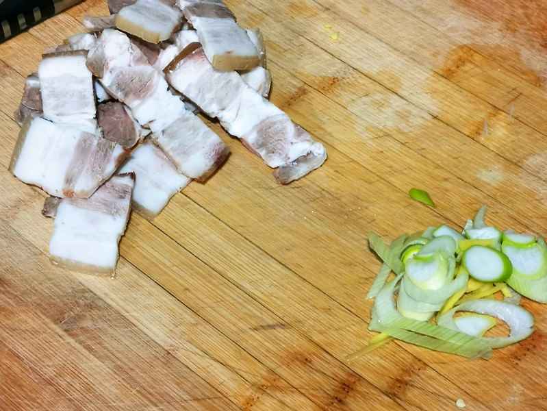 Cut the cooked pork belly into thin slices, chop the green onions